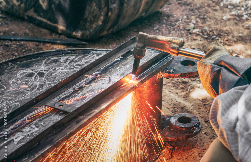Close up hand heavy industrial worker is working on metal work factory