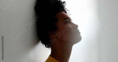 Contemplative young black woman leaning on wall. Pensive African American woman