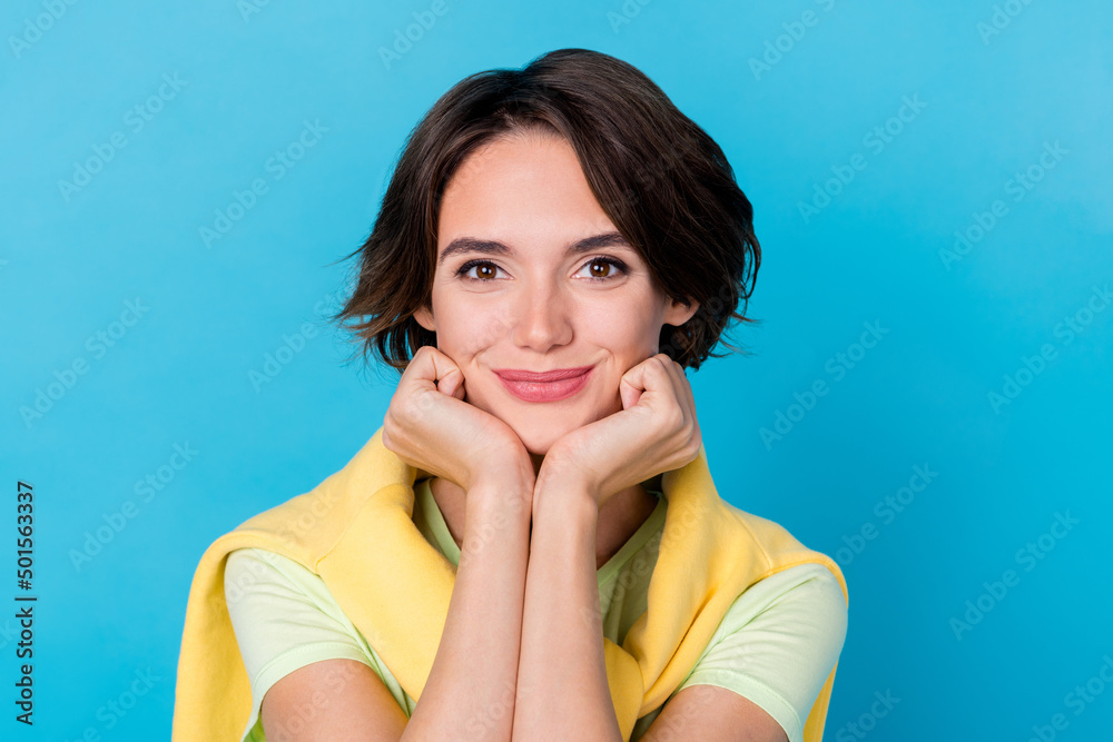 Photo of pretty young brunette lady hands face wear green t-shirt jumper isolated on blue color background Photo of pretty young brunette lady hands face wear green t-shirt jumper isolated on blue color background