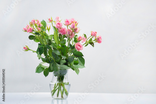 bouquet and bouquet pink roses in water in a glass vase isolated on a white background