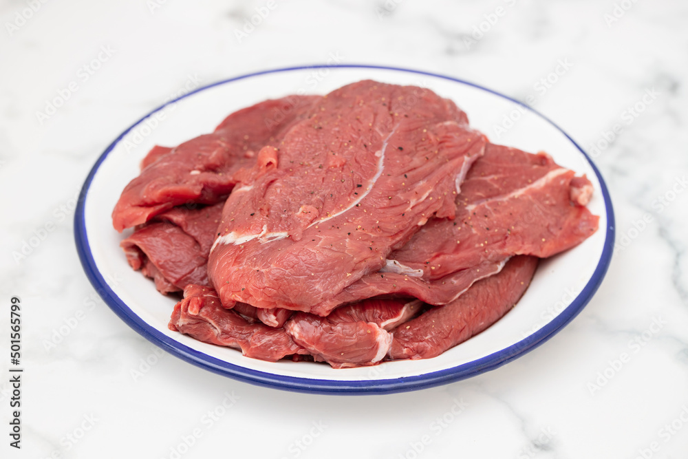 raw fresh meat with pepper on white dish raw fresh meat with pepper on white dish