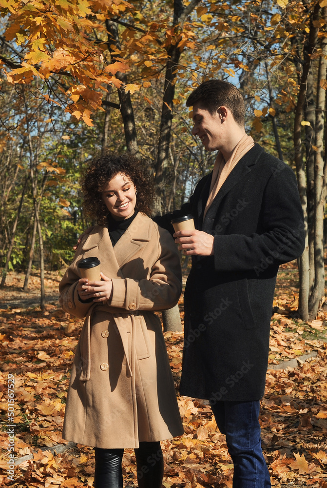 Beautiful young couple  in the autumn park with falling foliage. 