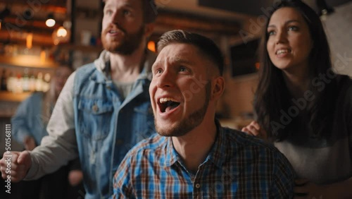 Portrait of a bearded male fan watching football in a bar with friends. World Cup, football, hockey, basketball. Sports fans upset about favorite sports team losing match, watching game in pub