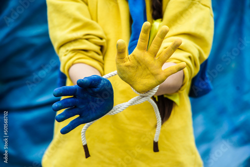 Children against war. Russia's invasion of Ukraine, a request for help to the world community. The child's hands are painted yellow and blue, a gesture of faith and hope. The hands of a  child