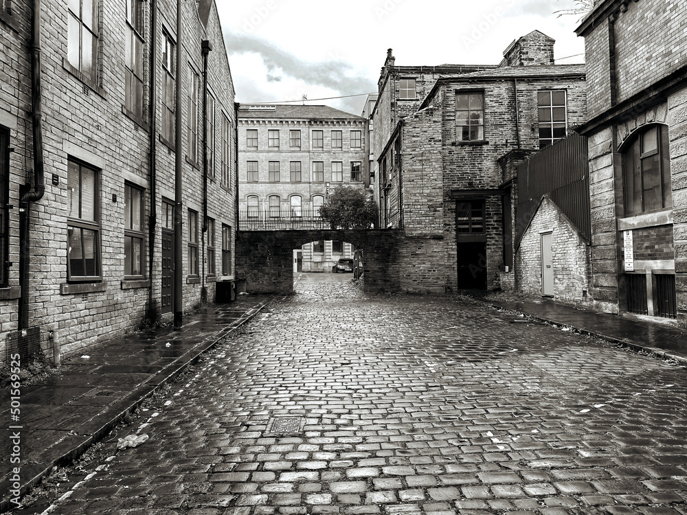 Victorian buildings, next to, Cater Street, lined with wet stone cobbles, on a rainy day in, Little Germany, Bradford, UK