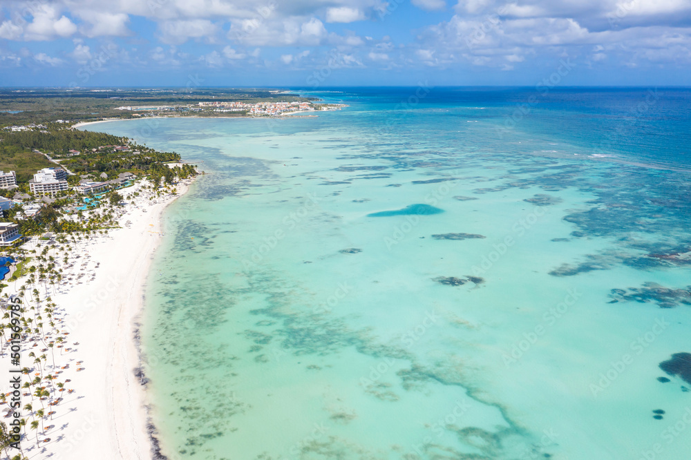 Juanillo beach with palm trees, white sand and turquoise caribbean sea. Cap Cana is a tourist area in Dominican Republic. Aerial view