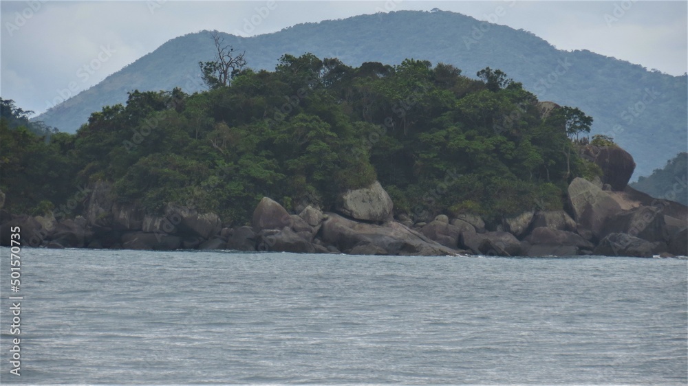 Island above rocks with mountain behind