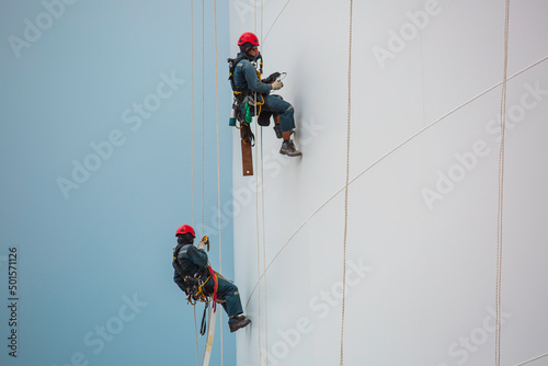 Male two workers down height tank rope access inspection of thickness shell plate storage tank.