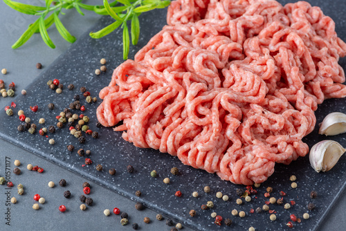 Photos Fresh raw minced pork and spices in a on a cutting board close up