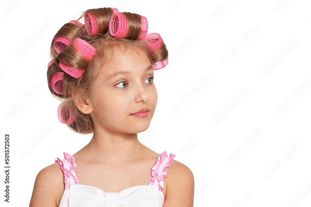 Portrait of emotional little pretty girl with hair curlers on white background