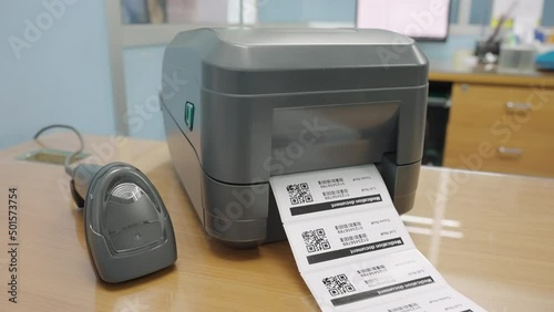 The black barcode printer is printing the bar code or QR code on the sticker.