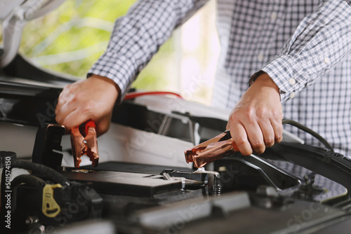 A mechanic is charging car battery pot