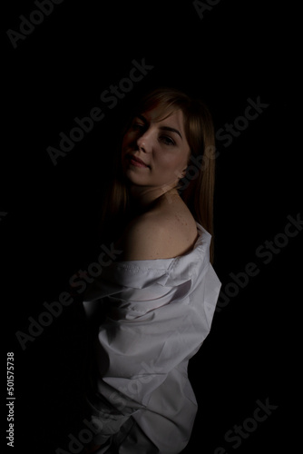 Young woman in a white shirt on a black background.