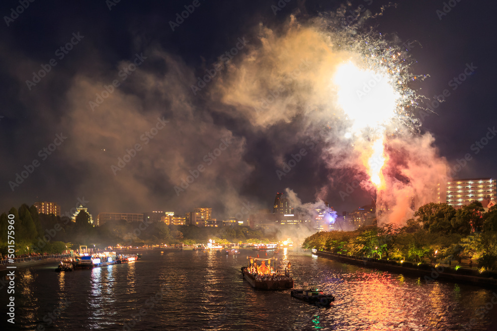 Bright fireworks at festive celebration along river at night