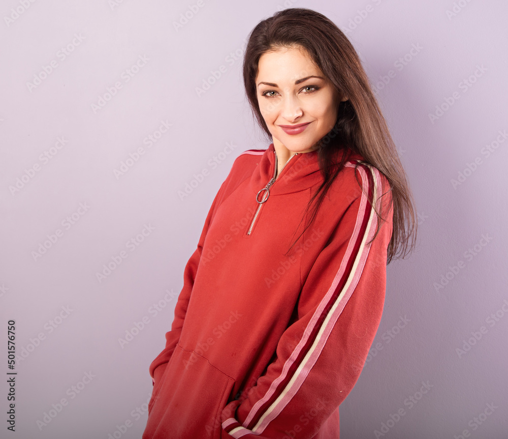 Fun enjoying smiling sporty woman posing in fashion red hoodie on purple bright background with empty copy space. Happy Fun enjoying smiling sporty woman posing in fashion red hoodie on purple bright background with empty copy space. Happy