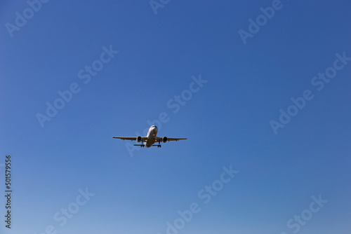 Airplane flying on the blue sky background.
