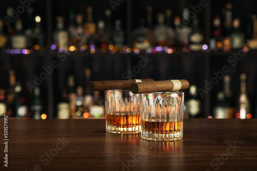 NO LOGOS OR TRADEMARKS!  SELF MADE LABELS!  Closed up view of glass of whiskey with cigars on top on color back