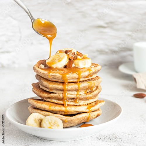 Wholegrain pancakes with banana and caramel sauce. Delicious breakfast.