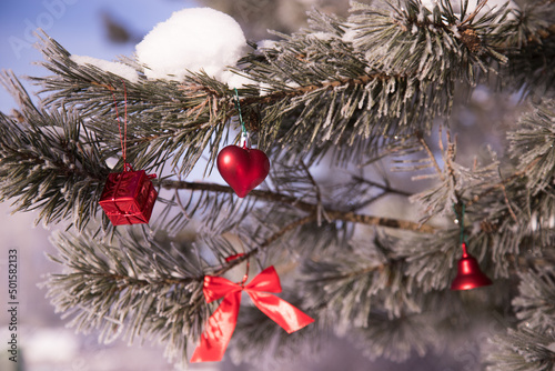 A snow-covered pine tree with Christmas toys.