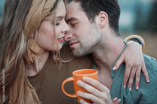 lovestory portrait handsome lovers with orange cup in a hand of man photo
