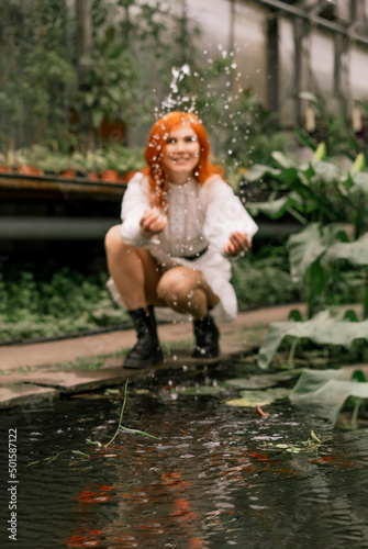 Fototapeta Naklejka Na Ścianę i Meble -  Red-haired girl walking in a tropical garden