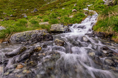 A small waterfall flowing into Oberbergbach river in austrian Stubai alps 