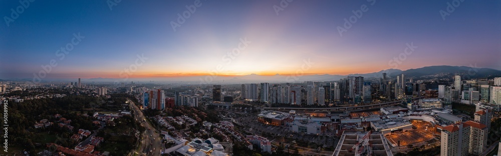 Naklejka premium Panoramic aerial photography of Mexico City at sunrise from the area of buildings in Santa Fe with the volcanoes in the background