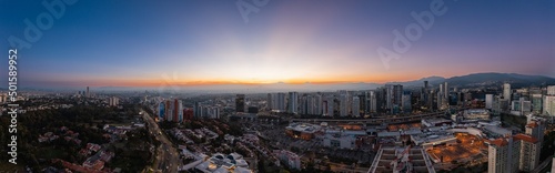 Panoramic aerial photography of Mexico City at sunrise from the area of buildings in Santa Fe with the volcanoes in the background