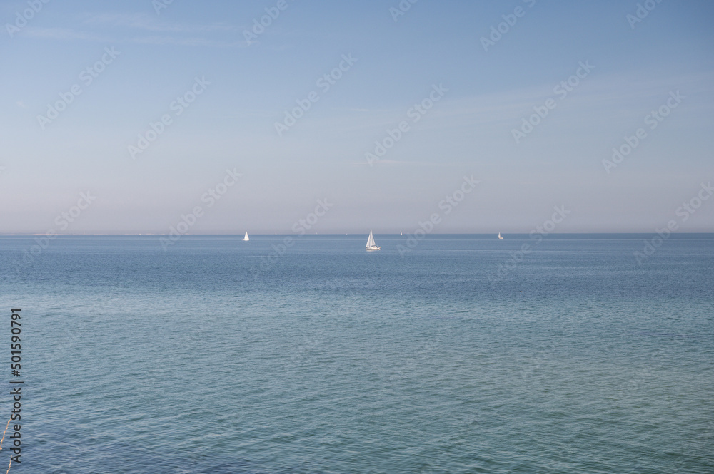 Blue sky without clouds with clear water and sailboards  away from the coast in north Germany