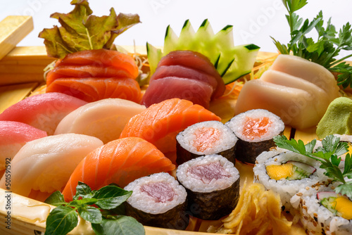 Japanese food mix including sushi and sashimi on wooden barge.