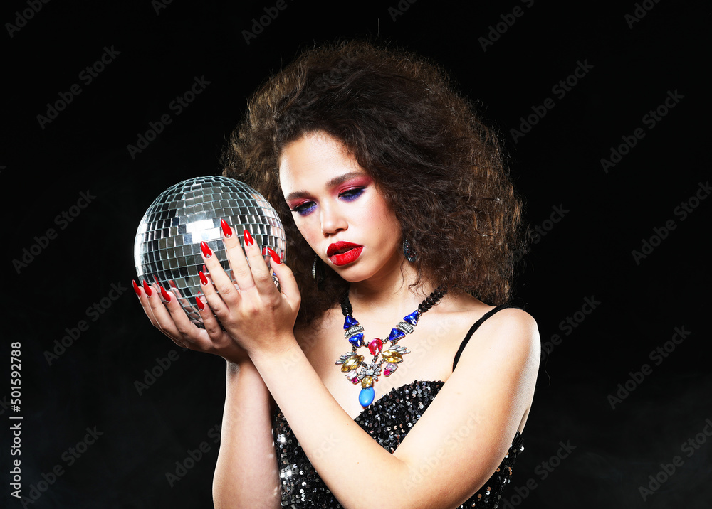 Naklejka premium Portrait of young beautiful african woman with bright make up holding disco balls