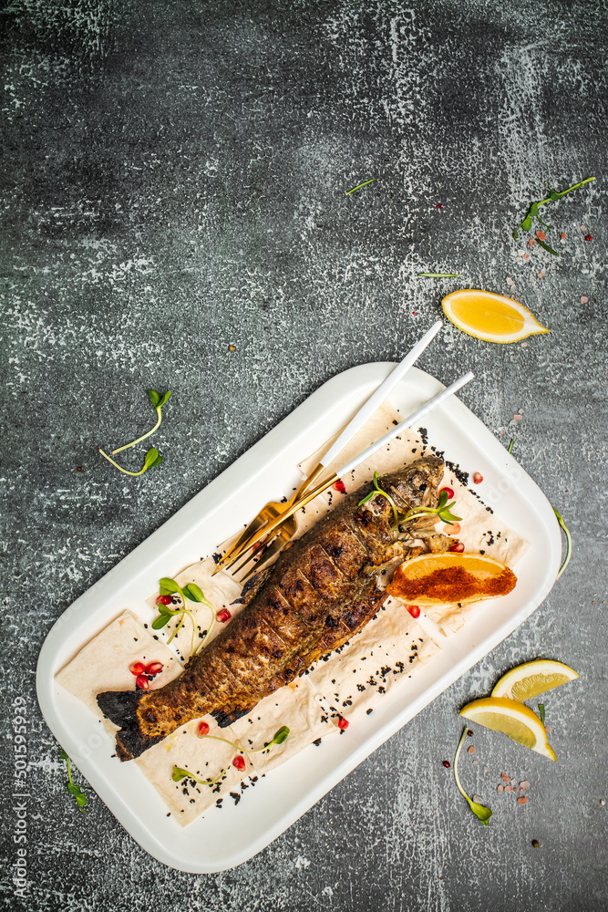 Baked trout fish with salt, lemon. Grilled trout. Fish dish fried fish