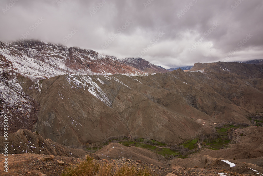 High Atlas Mountains in Morocco with snow on top and a stormy sky