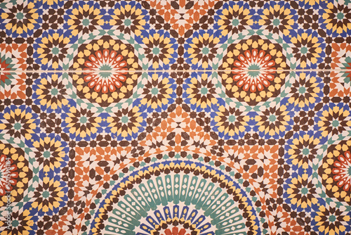 Detail of a moroccan painted multi-coloured traditional mosaic-tiled wall in blue  green  yellow  brown. Morocco