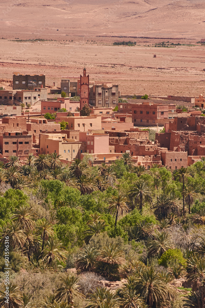 Earthen-clay old tradional kasbah with a palm trees plantation in the foreground. Moroccan landscape Earthen-clay old tradional kasbah with a palm trees plantation in the foreground. Moroccan landscape