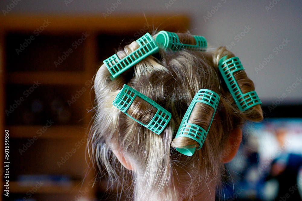 Fototapeta premium curling child's hair with curlers
