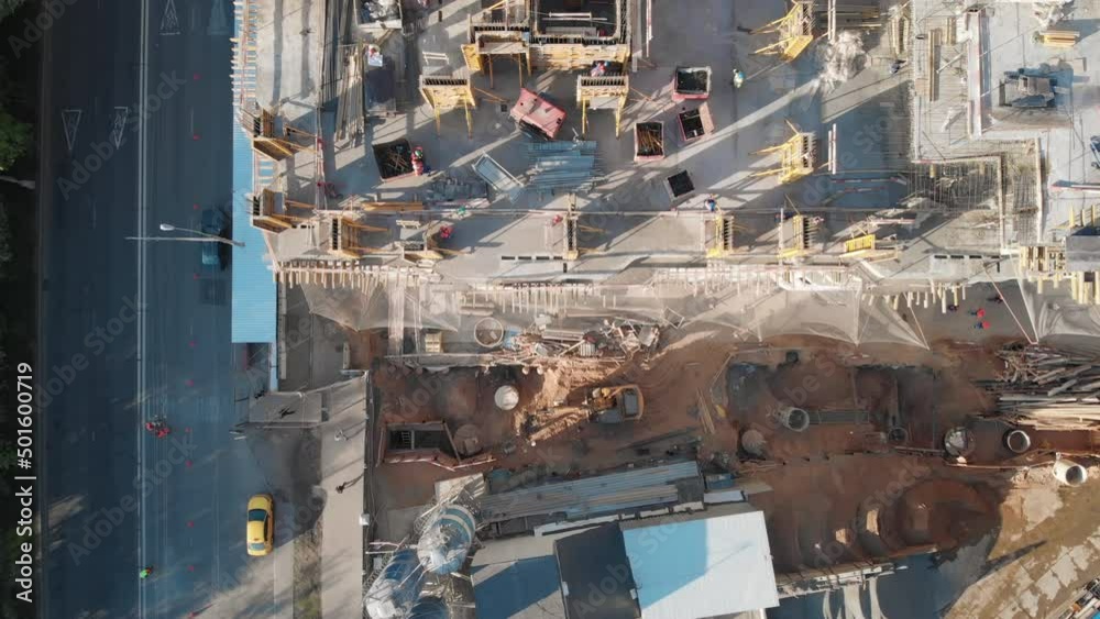 Top view to the construction works on the roof of a skyscraper. Camera moving above the building and cranes showing busy builders and all the details of the construction site. Top view to the construction works on the roof of a skyscraper. Camera moving above the building and cranes showing busy builders and all the details of the construction site.
