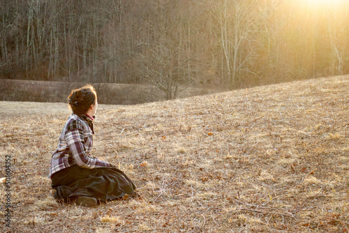 Woman sitting on brown hill