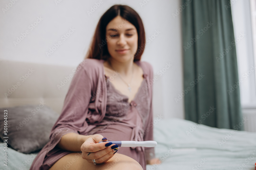 Happy young woman shows positive pregnancy test Happy young woman shows positive pregnancy test