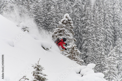 Skier rides fast on snowy mountain slope and splashing snow around him © fesenko