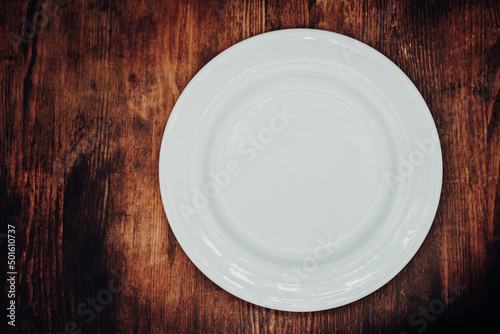 white empty plate on a wooden table