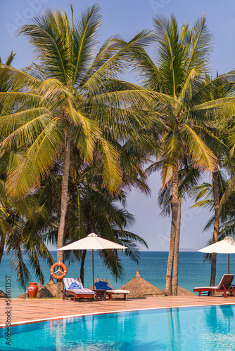 Fototapeta Naklejka Na Ścianę i Meble -  Beautiful tropical beach and sea with umbrella and chair around swimming pool in hotel resort for travel and vacation