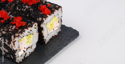 close-up, on a white table, Japanese shrimp rolls, fresh salad and flying fish caviar, there is a place for the inscription