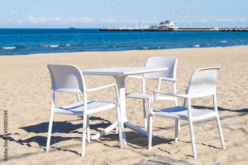 White chairs and table on the sandy beach