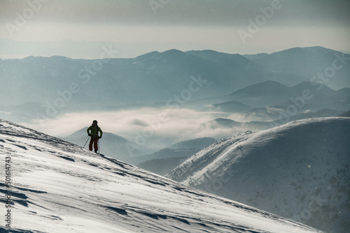 man skier in a ski suit stands and looks to the side photo