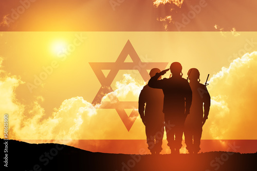 Silhouette of soldiers saluting against the sunrise in the desert and Israel flag. Concept - armed forces of Israel. photo