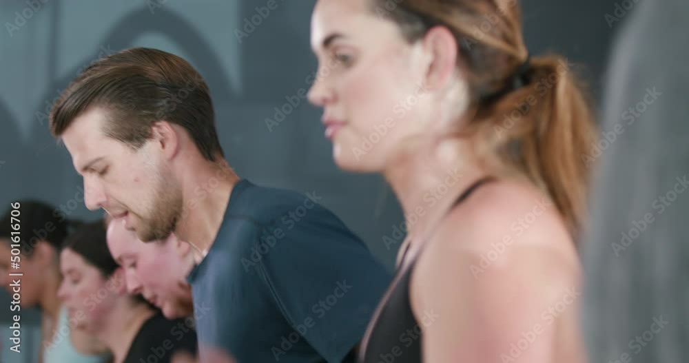 Group of fit athletes run on treadmills during an interval training Group of fit athletes run on treadmills during an interval training