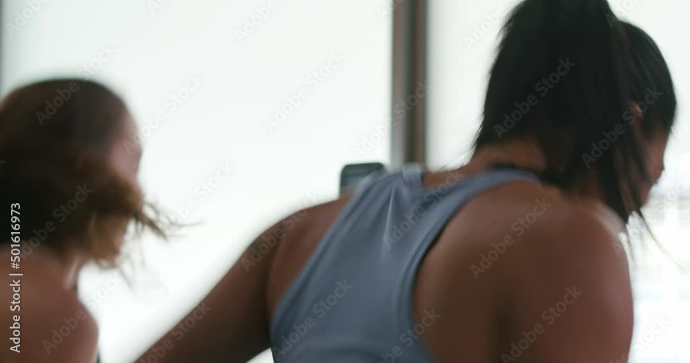 Fit women run uphill with resistance belts during an interval training workout on treadmills� Fit women run uphill with resistance belts during an interval training workout on treadmills�