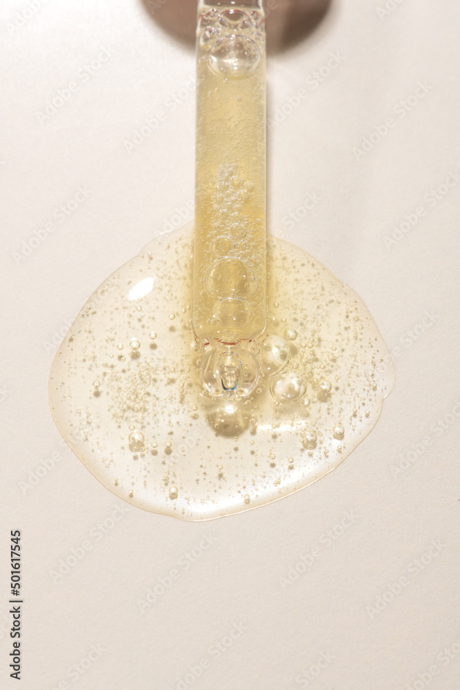 Top view of transparent pipette dropper with light golden drop of serum cosmetics, oil, gel ou cream on beige background and bubbles of air. Minimal beauty concept, macro closeup with copy space Top view of transparent pipette dropper with light golden drop of serum cosmetics, oil, gel ou cream on beige background and bubbles of air. Minimal beauty concept, macro closeup with copy space