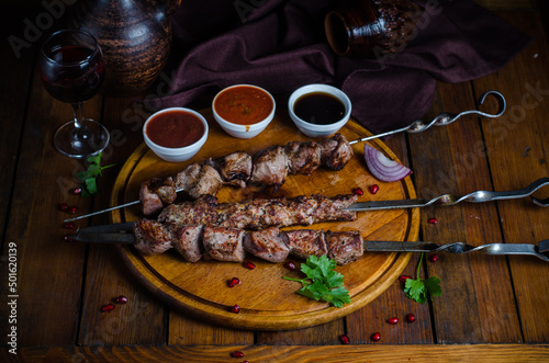 Set of shish kebabs or barbecue shashlik collection on charcoal background with with sauces. Skewered grilled cubes.